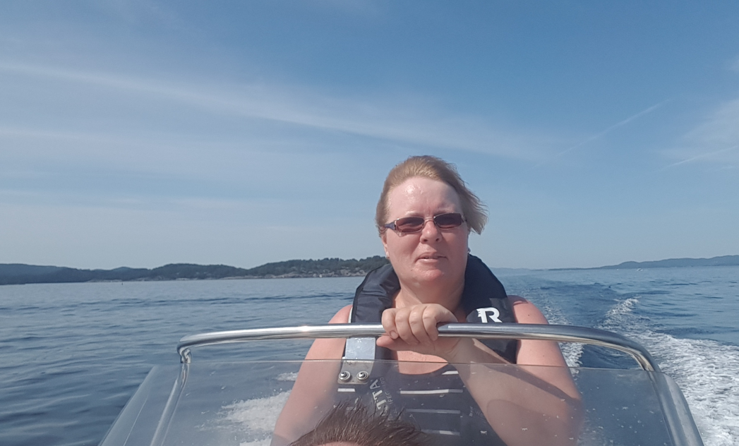 Roer som sitter i en liten trebåt med årer klare.